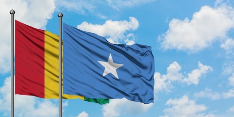 Guinea and Somalia flag waving in the wind against white cloudy blue sky together. Diplomacy concept, international relations.