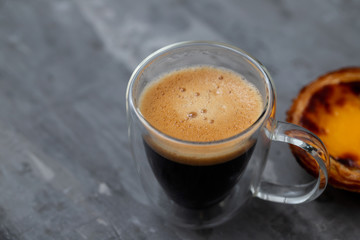 typical portuguese egg tart pastel de nata with cup of coffee on ceramic background