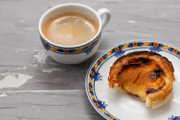 typical portuguese egg tart pastel de nata with cup of coffee on ceramic background
