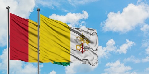 Guinea and Vatican City flag waving in the wind against white cloudy blue sky together. Diplomacy concept, international relations.