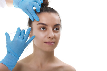 Facial Beauty Injections. Portrait Beautiful Young Woman Receiving Hyaluronic Acid Injection. Closeup Of Hands In Gloves Holding Syringe Near Attractive Female Face.