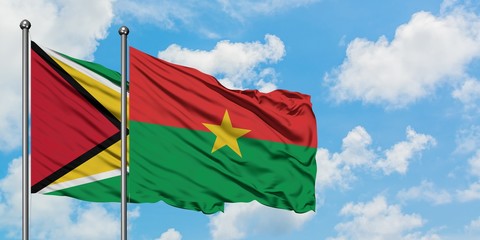 Guyana and Burkina Faso flag waving in the wind against white cloudy blue sky together. Diplomacy concept, international relations.