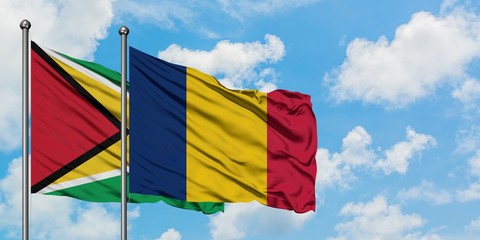 Guyana and Chad flag waving in the wind against white cloudy blue sky together. Diplomacy concept, international relations.