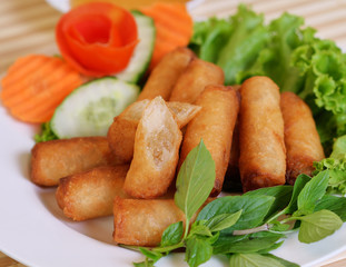 Spring Rolls, on white dish and wooden table / Selective focus