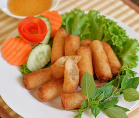  Spring Rolls, on white dish and wooden table / Selective focus