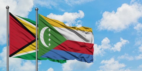 Guyana and Comoros flag waving in the wind against white cloudy blue sky together. Diplomacy concept, international relations.
