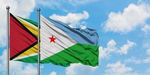 Guyana and Djibouti flag waving in the wind against white cloudy blue sky together. Diplomacy concept, international relations.