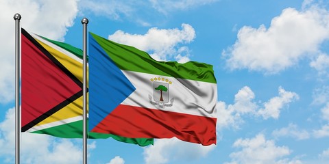 Guyana and Equatorial Guinea flag waving in the wind against white cloudy blue sky together. Diplomacy concept, international relations.