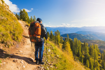 Man tourist in Alps. Magical landscape of the Dolomites with sun glare