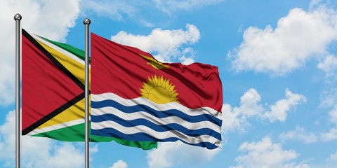 Guyana and Kiribati flag waving in the wind against white cloudy blue sky together. Diplomacy concept, international relations.