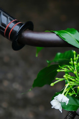 White flowers hanging on old handlebars.