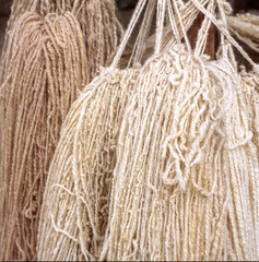 It is sheep wool. The weaving process takes a lot of time and dedication. You need the artisan work to collect the raw material, transform the wool into threads, dye them, and then start knitting.