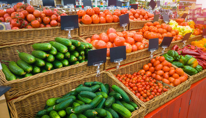 Food market vegetables with blank price tag labels. Various fresh ripe cucumbers, tomatoes, peppers and other agriculture products on marketplace sale.