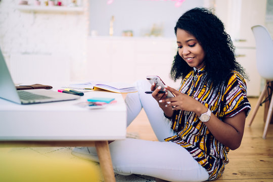 Smiling Black Teenager Using Smartphone At Home