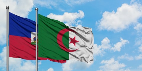 Haiti and Algeria flag waving in the wind against white cloudy blue sky together. Diplomacy...