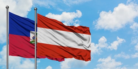 Haiti and Austria flag waving in the wind against white cloudy blue sky together. Diplomacy concept, international relations.