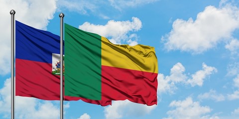 Haiti and Benin flag waving in the wind against white cloudy blue sky together. Diplomacy concept, international relations.
