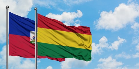 Haiti and Bolivia flag waving in the wind against white cloudy blue sky together. Diplomacy concept, international relations.