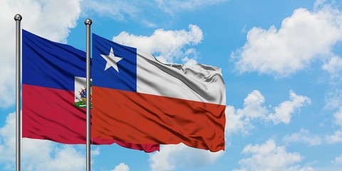 Haiti and Chile flag waving in the wind against white cloudy blue sky together. Diplomacy concept, international relations.