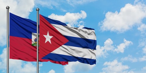 Haiti and Cuba flag waving in the wind against white cloudy blue sky together. Diplomacy concept, international relations.