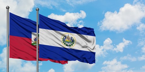 Haiti and El Salvador flag waving in the wind against white cloudy blue sky together. Diplomacy concept, international relations.