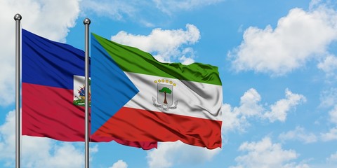 Haiti and Equatorial Guinea flag waving in the wind against white cloudy blue sky together. Diplomacy concept, international relations.