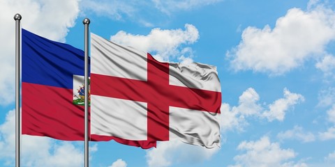 Haiti and England flag waving in the wind against white cloudy blue sky together. Diplomacy concept, international relations.