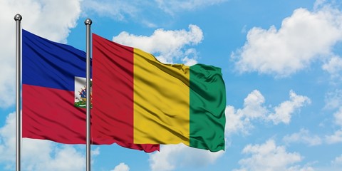 Haiti and Guinea flag waving in the wind against white cloudy blue sky together. Diplomacy concept, international relations.
