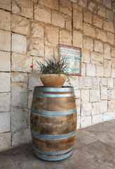 Wine barrel and flower pot near the entrance to the Psagot winery in Samaria region in Benjamin district, Israel - obrazy, fototapety, plakaty
