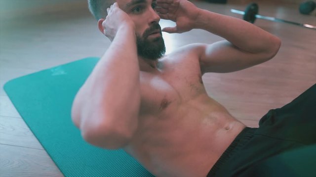Healthy fit man working abs, abdomen with sit up. Handsome men is hardworking, exercising on bodybuilding center. 