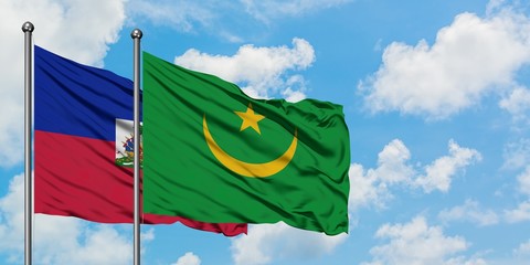 Haiti and Mauritania flag waving in the wind against white cloudy blue sky together. Diplomacy concept, international relations.
