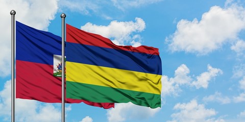 Haiti and Mauritius flag waving in the wind against white cloudy blue sky together. Diplomacy concept, international relations.