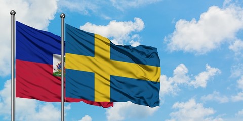 Haiti and Sweden flag waving in the wind against white cloudy blue sky together. Diplomacy concept, international relations.