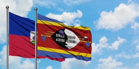 Haiti and Swaziland flag waving in the wind against white cloudy blue sky together. Diplomacy concept, international relations.
