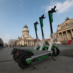 electric scooters are parked at the Gendarmenmarkt in Berlin. a number of e-scooters on the...