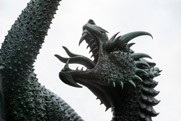 sculpture: dragon head with open mouth against the sky. The dragon struck by St. George.