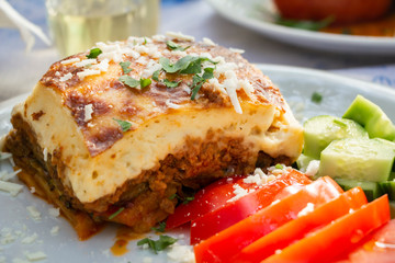Greek traditional moussaka on a white plate served in taverna, Greece