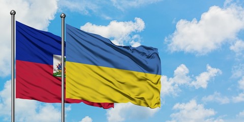 Haiti and Ukraine flag waving in the wind against white cloudy blue sky together. Diplomacy concept, international relations.