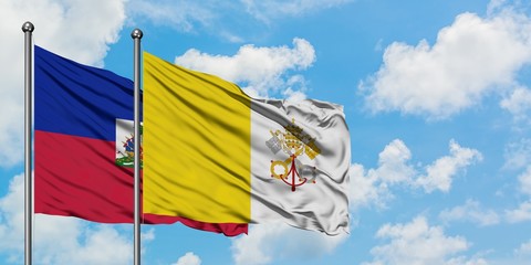 Haiti and Vatican City flag waving in the wind against white cloudy blue sky together. Diplomacy concept, international relations.