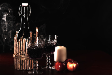 Wine bottle on a table with two crystal glasses. Apples and candle.