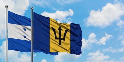 Honduras and Barbados flag waving in the wind against white cloudy blue sky together. Diplomacy concept, international relations.