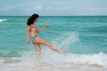 Teenage girl on beach in Miami Florida having fun playing in the water