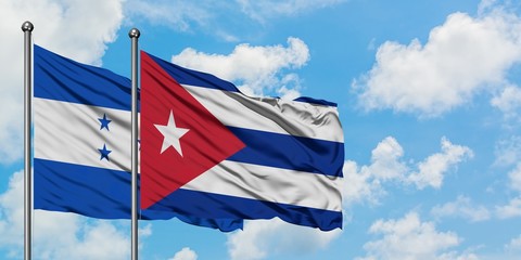 Honduras and Cuba flag waving in the wind against white cloudy blue sky together. Diplomacy...