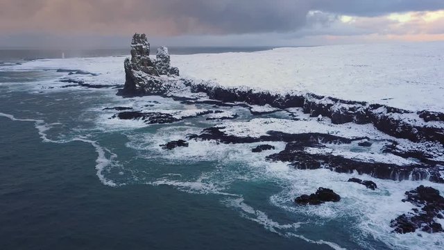 Flying backward at Londrangar cliffs, Snaefellsnes peninsula, Iceland (aerial view from drone)