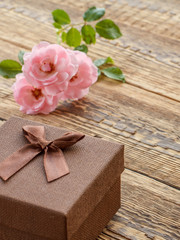 Gift box on wooden boards with rose flowers