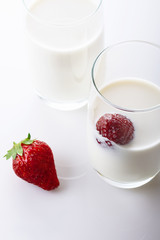 Fresh, juicy strawberry in cream on white background. Close up. Selective focus. High key.