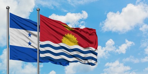 Honduras and Kiribati flag waving in the wind against white cloudy blue sky together. Diplomacy concept, international relations.