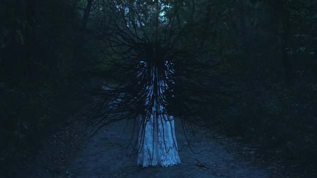 Woman virus host, monster with black tentacles standing in woods, transformation. Mutation horror scene