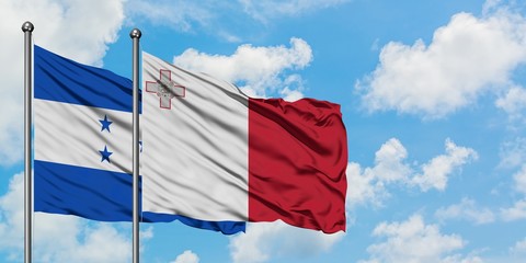 Honduras and Malta flag waving in the wind against white cloudy blue sky together. Diplomacy concept, international relations.
