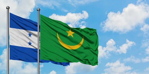 Honduras and Mauritania flag waving in the wind against white cloudy blue sky together. Diplomacy concept, international relations.